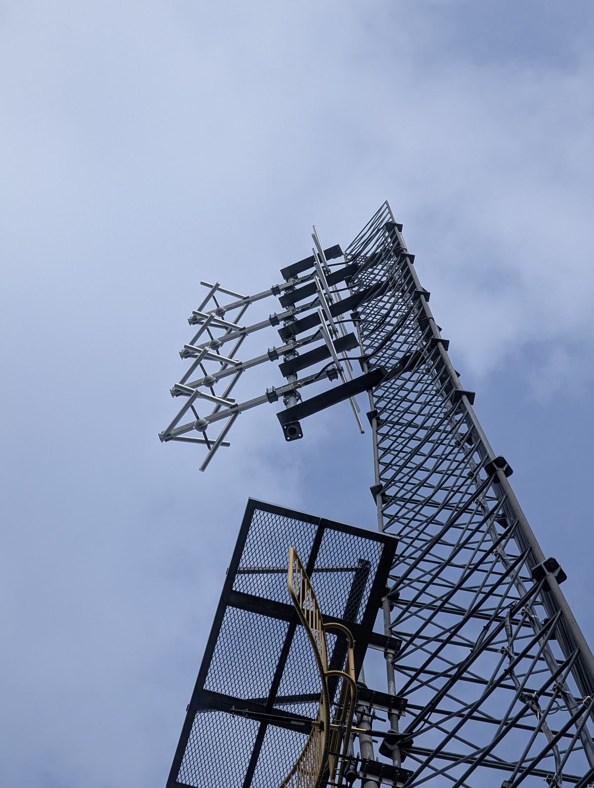 Antenna array and microwave dish mounted near the top of a tower